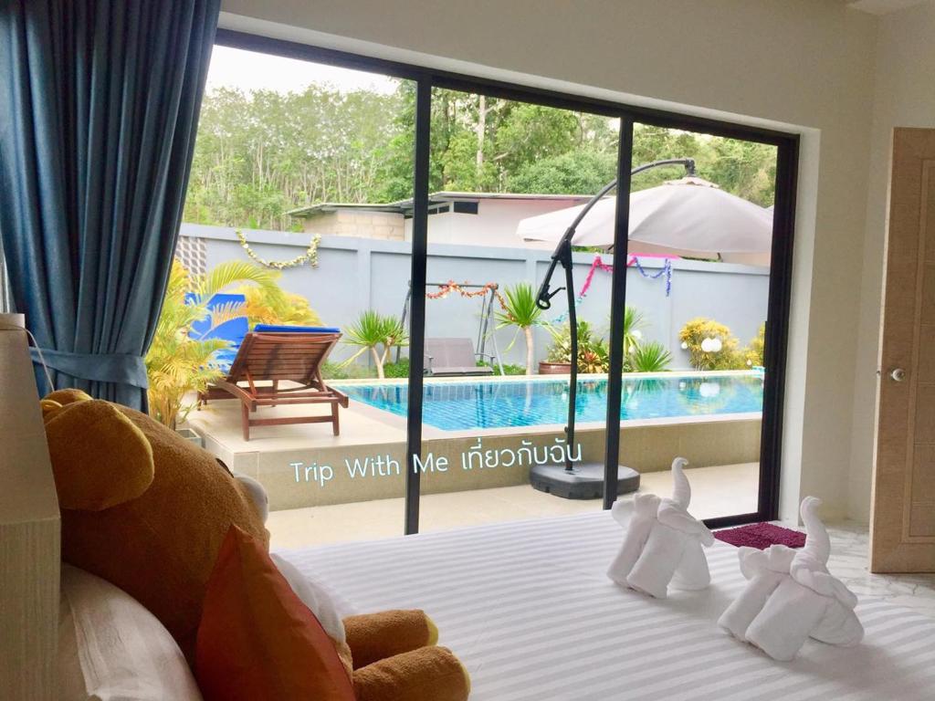 a bedroom with a bed with a view of a pool at Siri Nathai Pool Villa สิรินาไทย พูลวิลล่า in Krabi