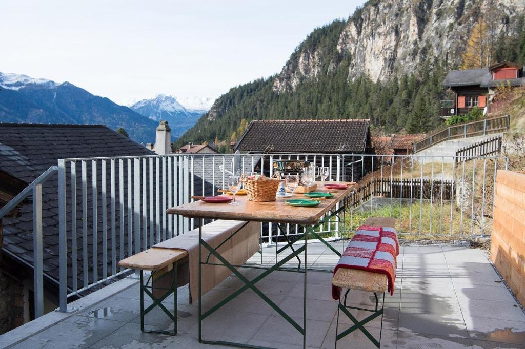 a table and two chairs on a balcony with mountains at Large alpine house for 10 with panoramic view in Schmitten