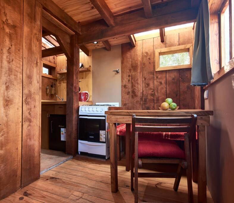 una cocina con una mesa con fruta. en Calida Mini Casa en San Carlos de Bariloche