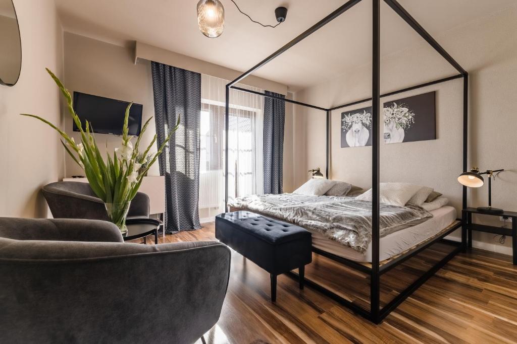 a bedroom with a canopy bed and a chair at Bystry Comfort in Bukowina Tatrzańska