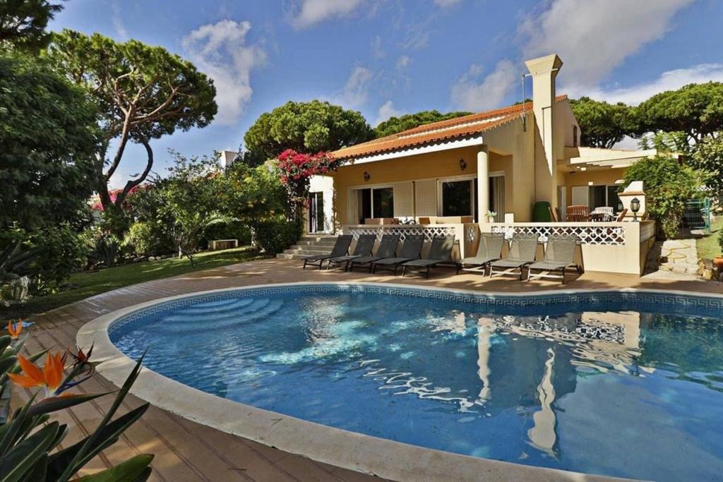 a swimming pool in front of a house at Villa Quadradinhos 21Q - luxurious 4 bedroom Vale do Lobo villa with private heated pool in Vale do Lobo