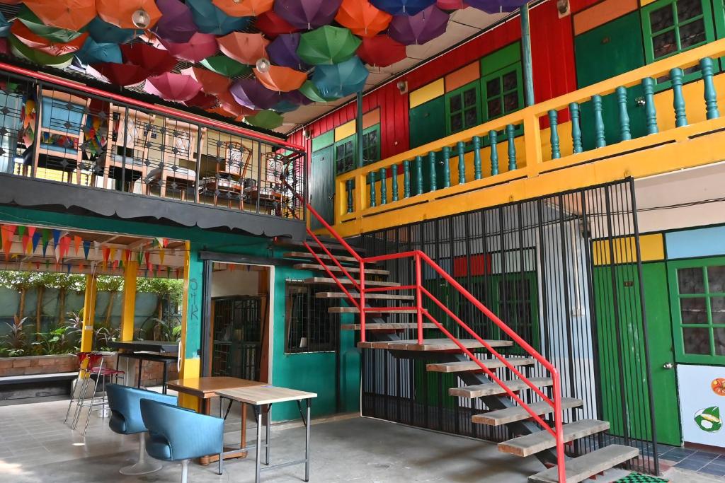 a colorful building with a staircase and tables and chairs at MARIA Guesthouse in Phra Nakhon Si Ayutthaya