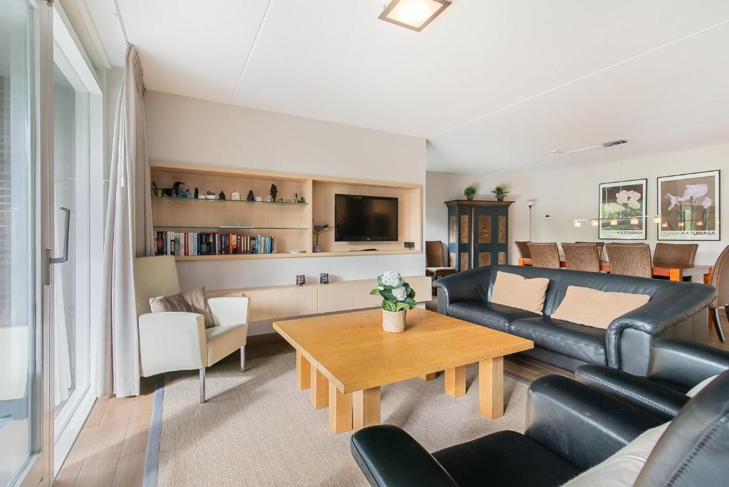 ein Wohnzimmer mit einem Sofa und einem Tisch in der Unterkunft Hello Zeeland - Appartement Loverendale 10 in Domburg