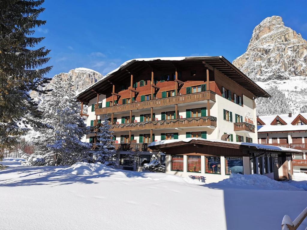 un hotel en las montañas con nieve en el suelo en Hotel la Plaza, en Corvara in Badia