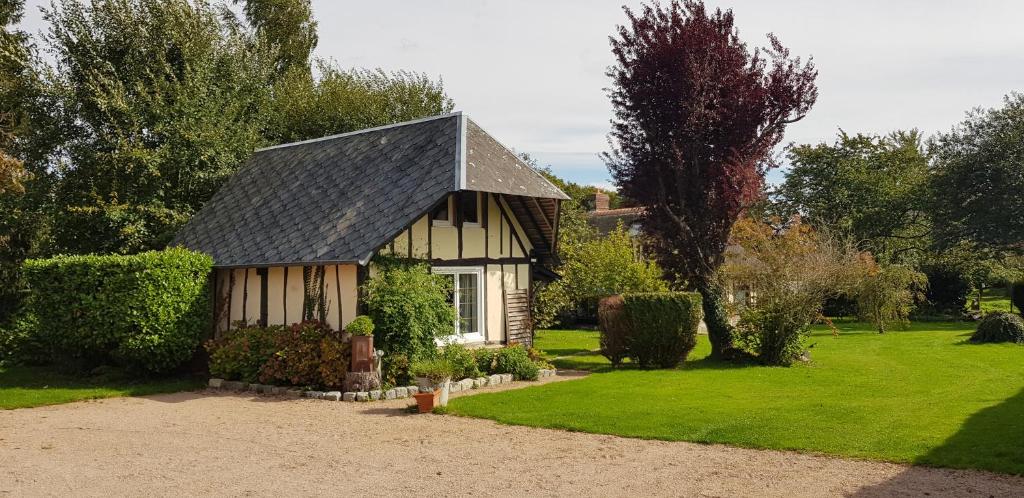 una pequeña casa en un patio con césped verde en La petite maison en Le Bosc-Roger-en-Roumois