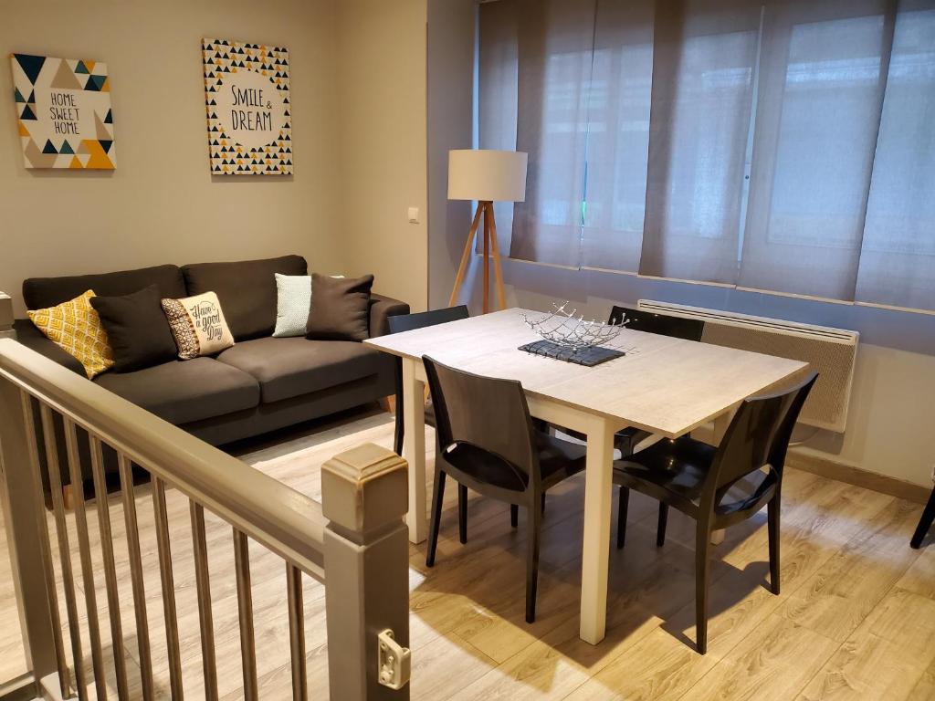 sala de estar con mesa y sofá en Emplacement de 1er choix situé dans une impasse- Prestations de qualité - WiFi, en Cauterets