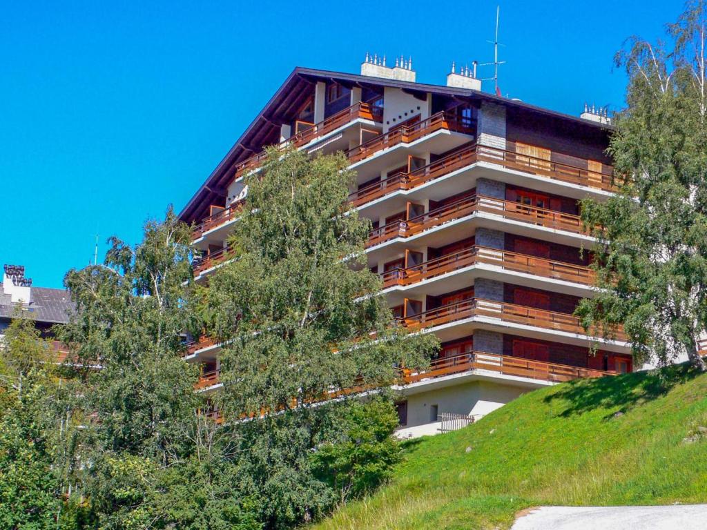 a building on top of a hill with trees at Studio Quille du Diable 4 by Interhome in Nendaz