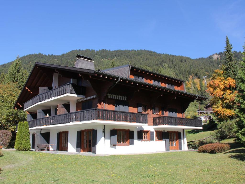 a large house with a mountain in the background at Apartment Rose des Vents 4 by Interhome in Villars-sur-Ollon