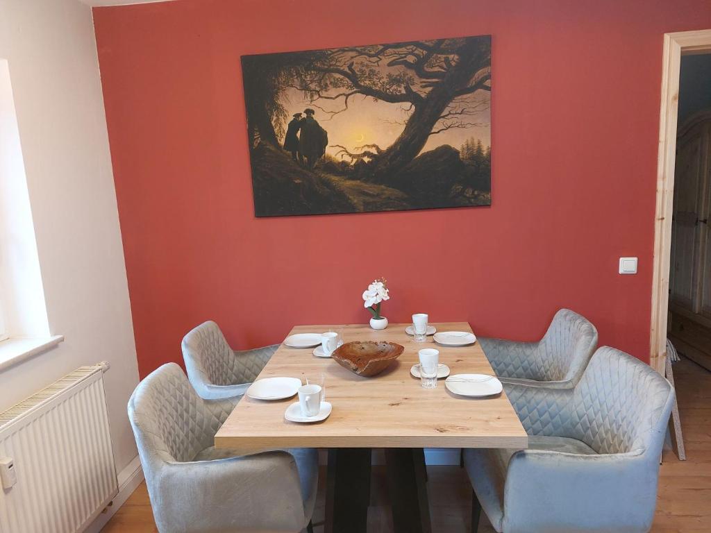 einen Holztisch mit Stühlen und ein Gemälde an der Wand in der Unterkunft Apartment Räuberhauptmann Karasek by Interhome in Hain