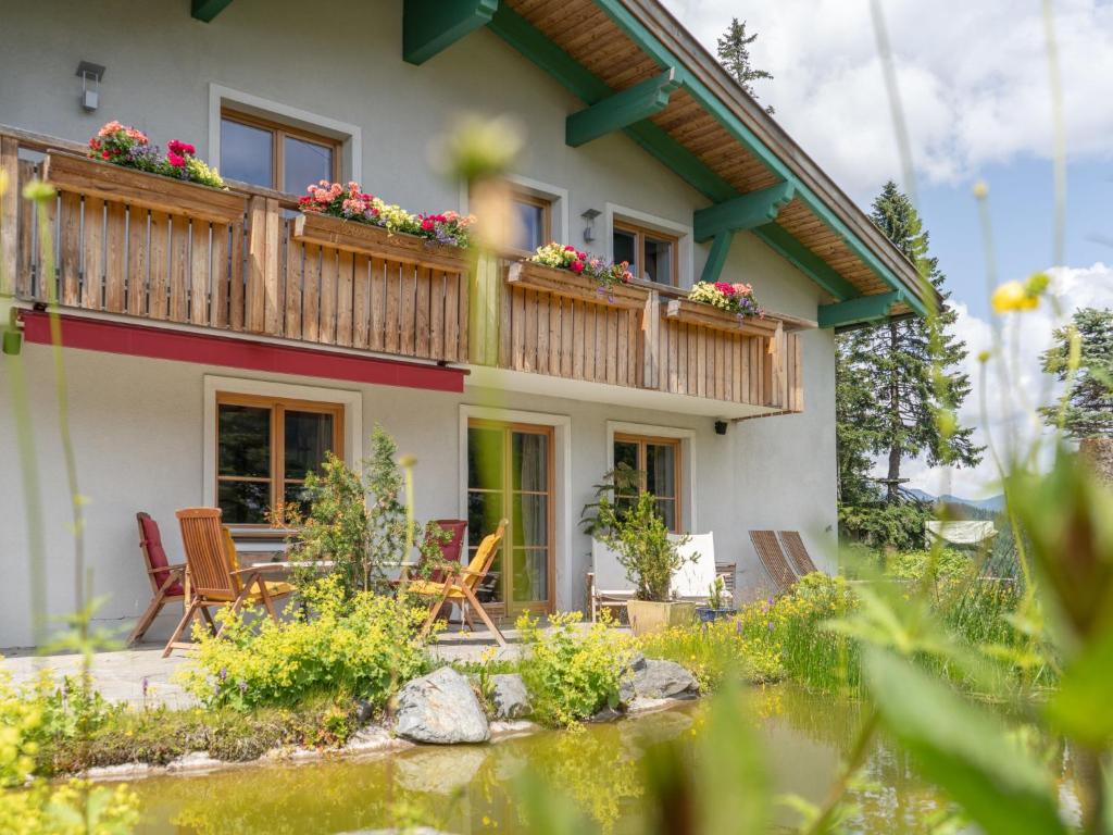 Casa con balcón con sillas y mesa. en Holiday Home Haus Katschberg 8 by Interhome en Rennweg
