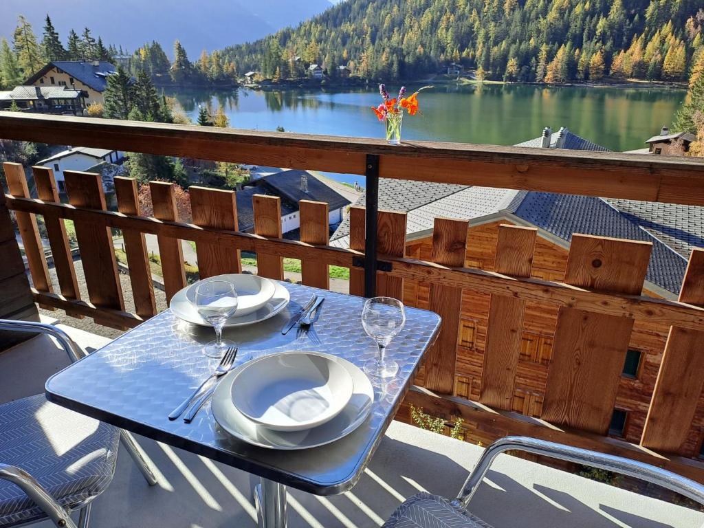 a table on a balcony with a view of a lake at Apartment Parc B428 by Interhome in Champex