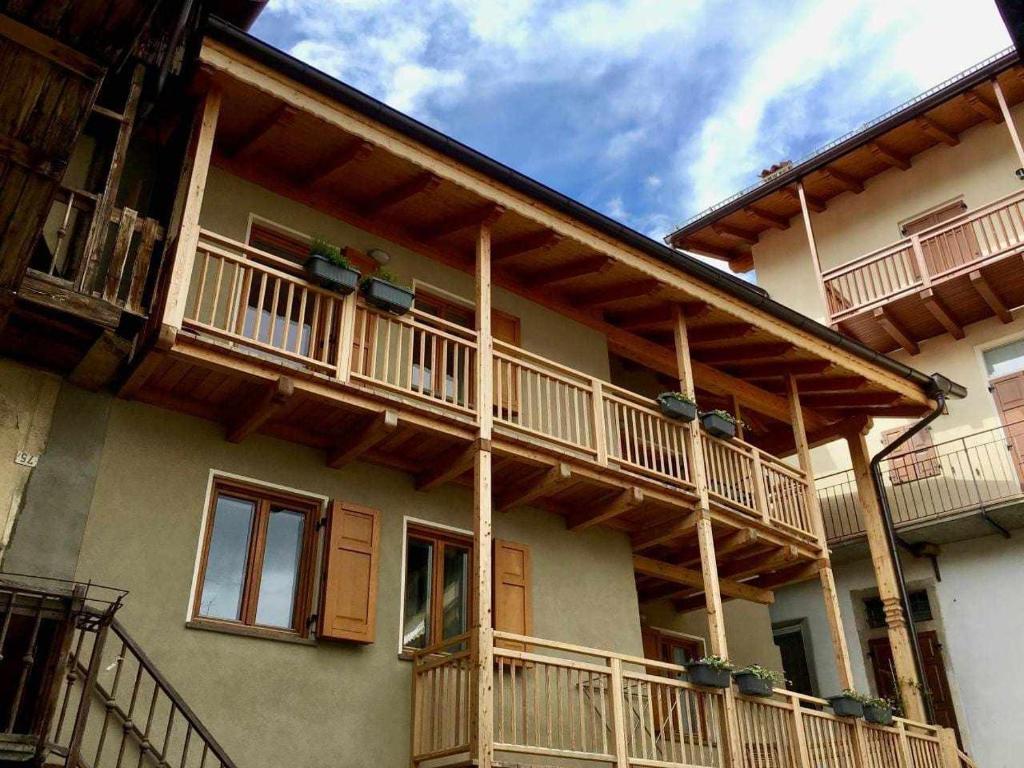 un edificio con balcones de madera en un lateral en Appartamento Al Garibaldi, en Levico Terme