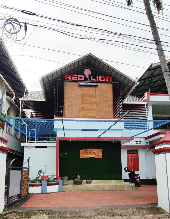 a building with a red lion sign on top of it at RED LION in Varkala