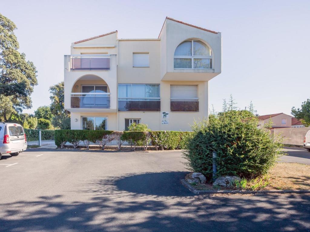 un bâtiment blanc avec un bush devant lui dans l'établissement Apartment Les Fées de Mirbois by Interhome, à Vaux-sur-Mer