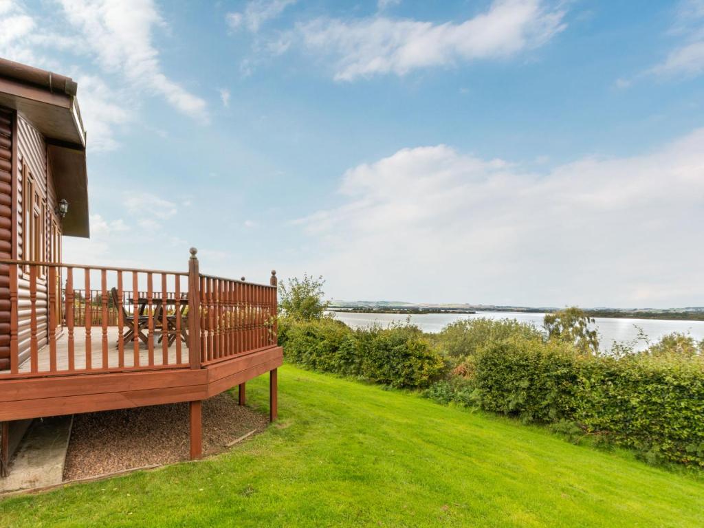 a large deck with a view of the water at Chalet Loch Side Lodge 5 by Interhome in Kinross