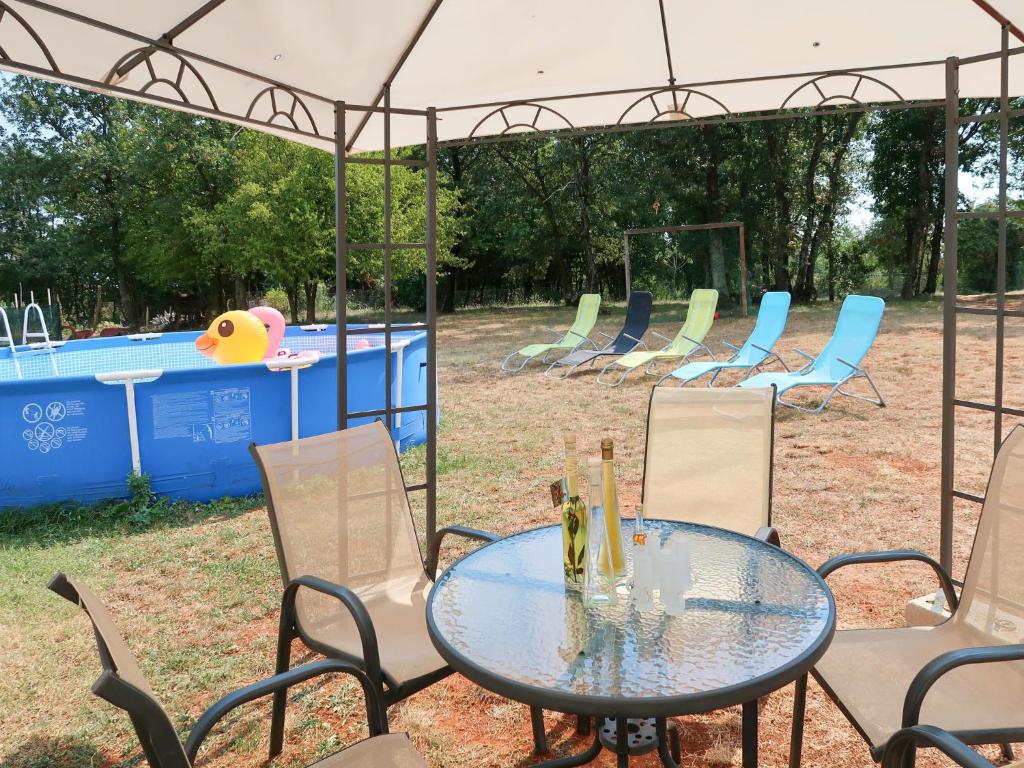 a table and chairs with a pool in the background at Apartment Biletić - LBN374 by Interhome in Barban