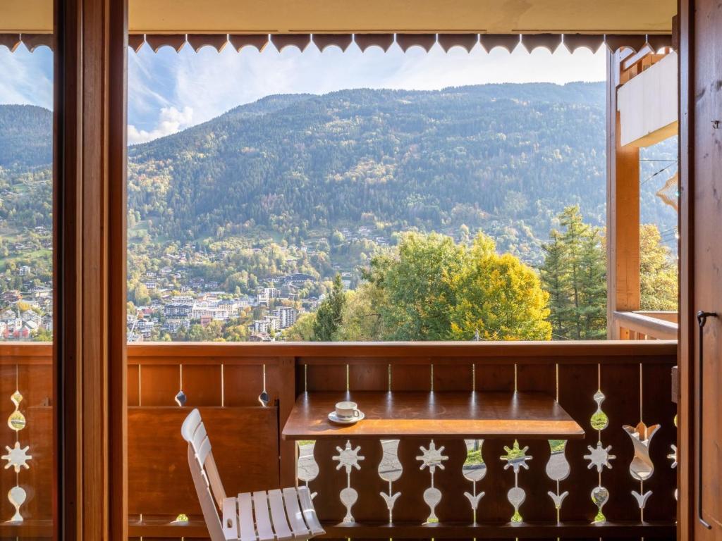une table et des chaises dans une pièce avec une grande fenêtre dans l'établissement Apartment Aiguilles du Midi by Interhome, à Saint-Gervais-les-Bains
