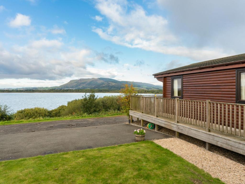 a log cabin with a view of a lake at Chalet Loch Side Lodge 8 by Interhome in Kinross