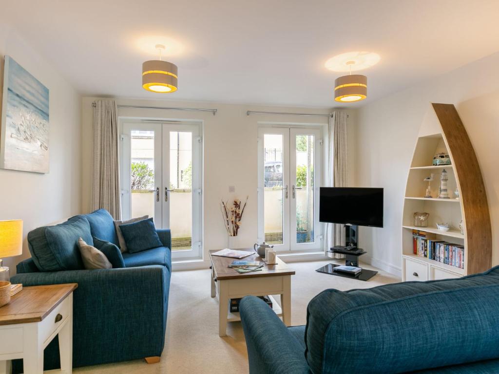 een woonkamer met twee blauwe banken en een tv bij Apartment Stones Throw by Interhome in St Austell