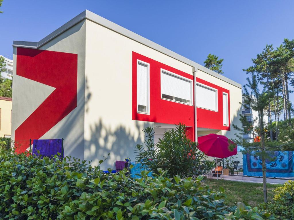 a red and white building with a red at Apartment Primula by Interhome in Bibione