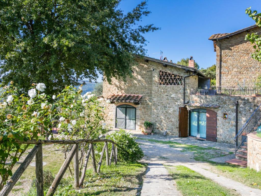 um velho edifício de pedra com uma árvore e uma entrada em Apartment L'Angolo di Uzzano by Interhome em Greve in Chianti