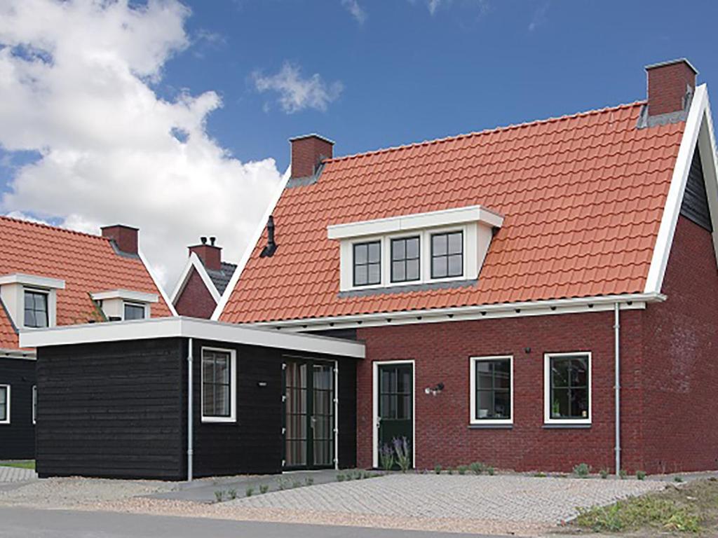 une maison en briques rouges avec un toit orange dans l'établissement Holiday Home Ganuenta-1 by Interhome, à Colijnsplaat
