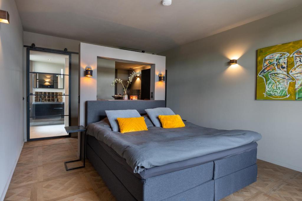 a bedroom with a bed with two yellow pillows at ShortStay Gouda in Gouda