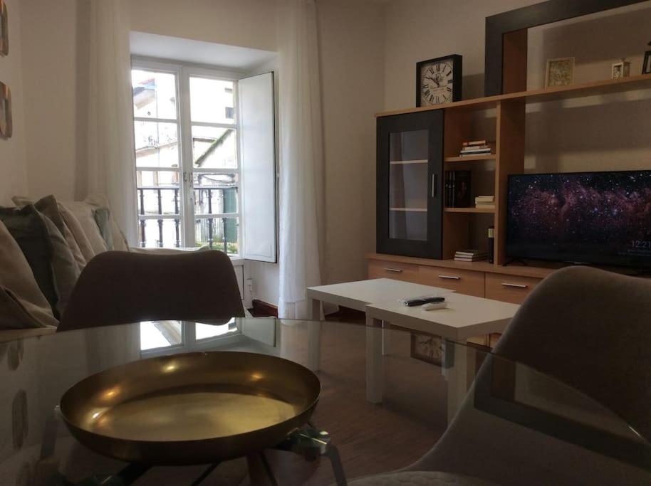 a living room with a table and a tv at HyP - A Casa do Correo Vello 1ºA / O TEMPO in Pontevedra