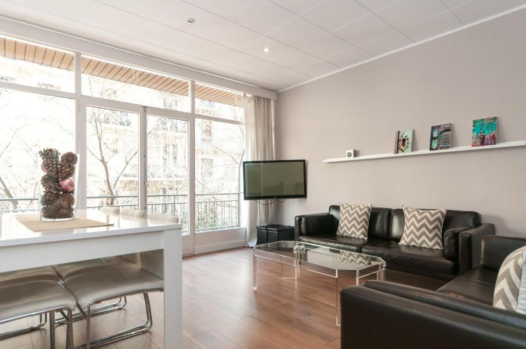 uma sala de estar com um sofá e uma televisão em Aribau em Barcelona