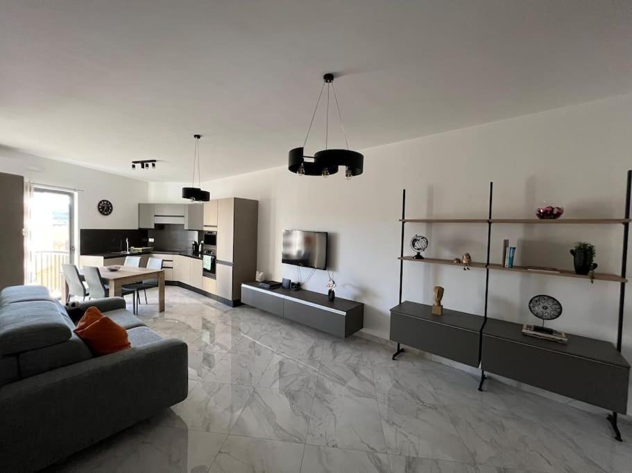 sala de estar amplia con sofá y cocina en Gozo - 3 Bedroom - Brand New en Żebbuġ