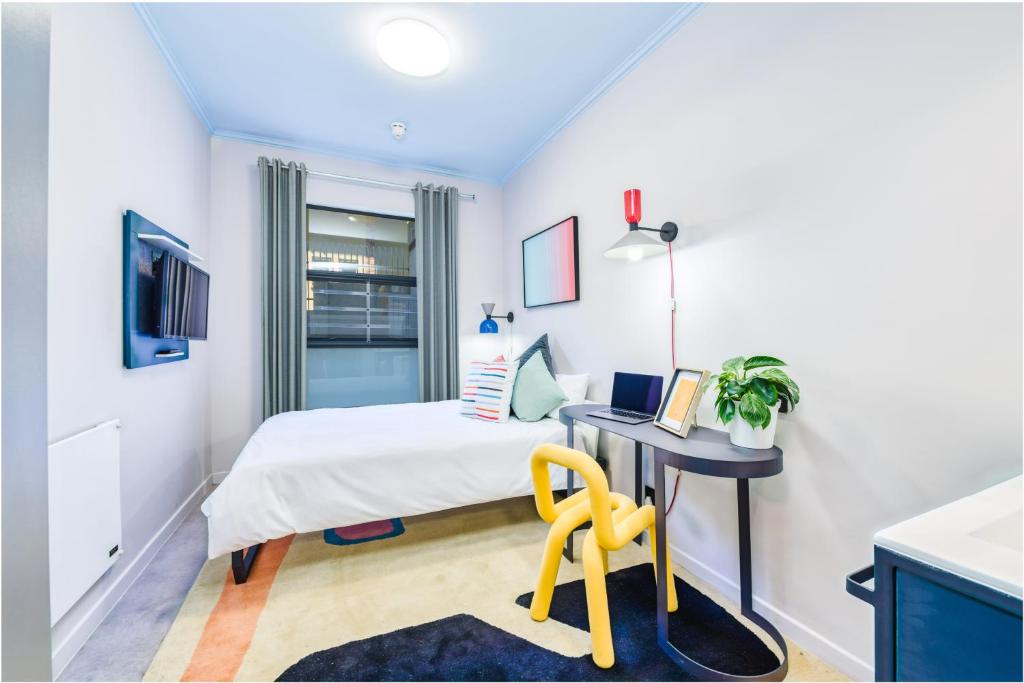 a bedroom with a bed and a desk with a chair at CampusKey Cape Town in Cape Town