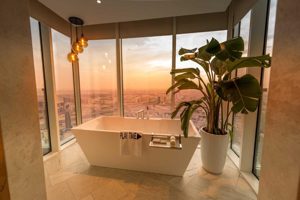 a bathroom with a bath tub in front of a window at FIVE Jumeirah Village in Dubai