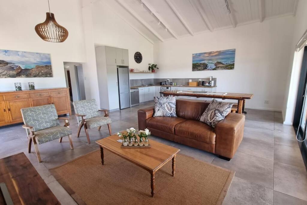 Bestuis Cottage - Self catering accommodation on a farm في Klapmuts: غرفة معيشة مع أريكة وطاولة