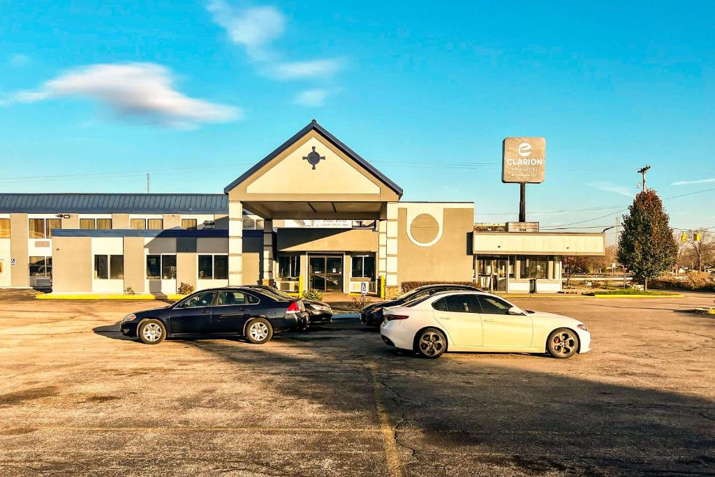 tres autos estacionados en un estacionamiento frente a un edificio en Clarion Inn & Suites, en Norton Shores