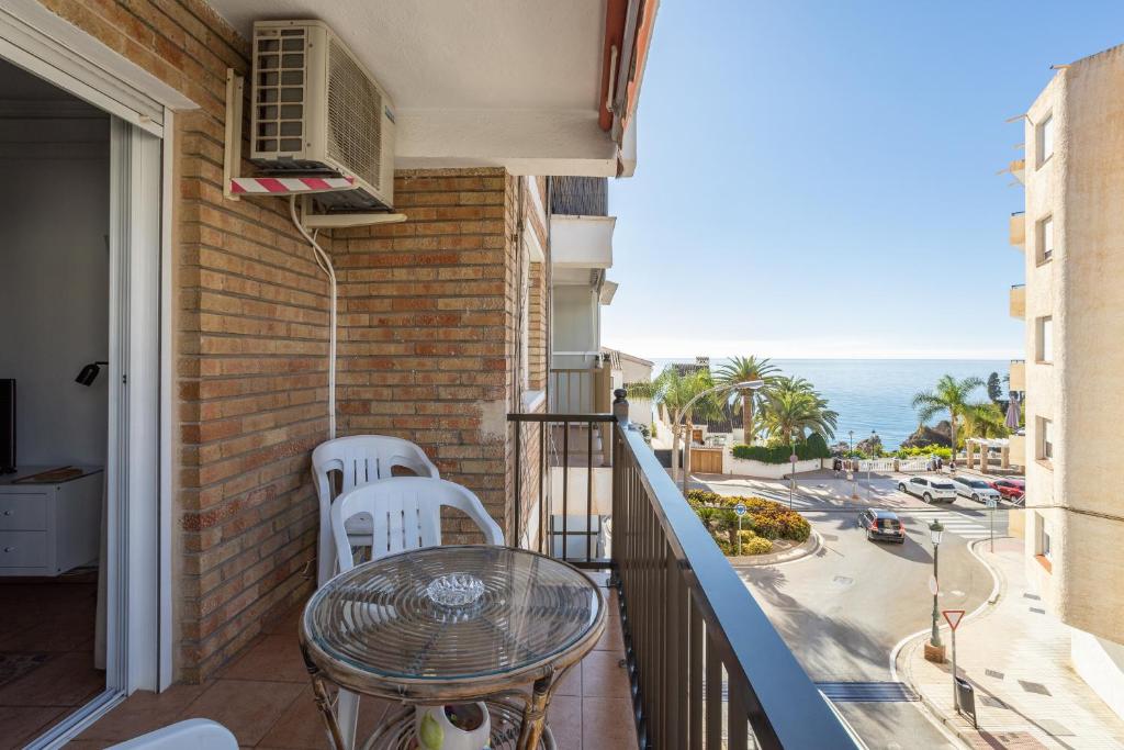 ein Balkon mit Tisch und Stühlen und Blick auf das Meer in der Unterkunft Bahia 327 in Nerja