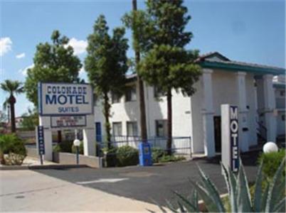 a motel with a sign in front of a building at Colonade Motel Suites in Mesa