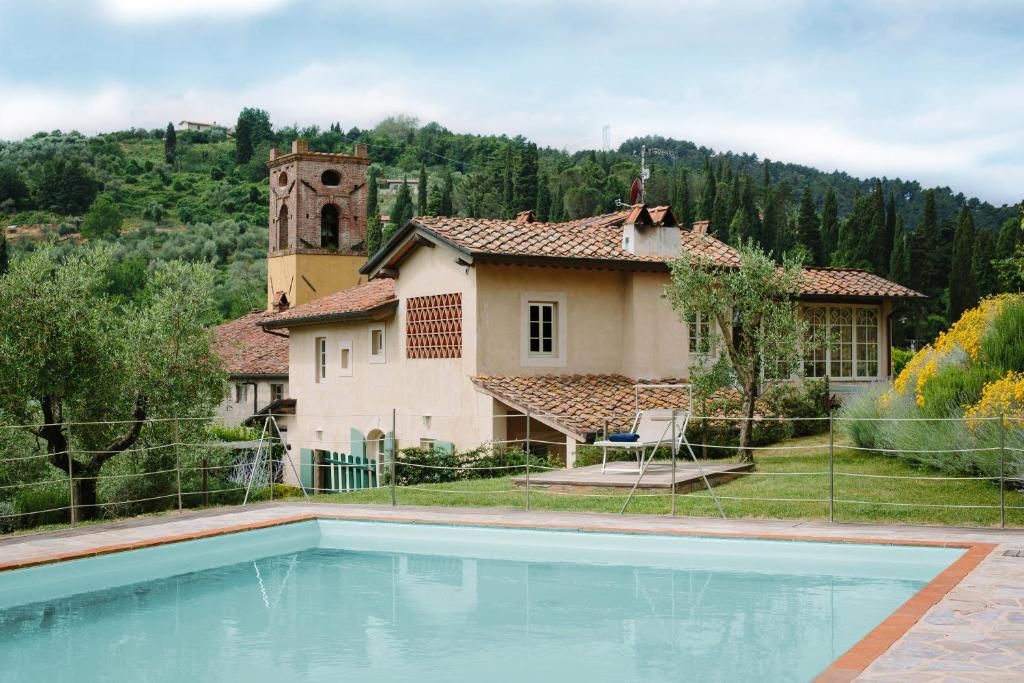 una casa con piscina frente a una casa en Agriturismo Mareli, en Camaiore