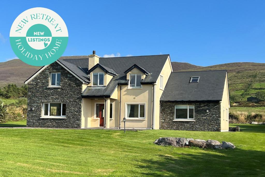 a house on a green lawn with the new reflin properties logo at Valentia View Holiday Home in Cahersiveen