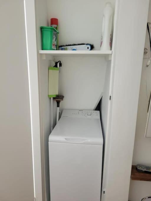 a white refrigerator in a room with a shelf at Modern Design One Bedroom Apartment in Paris
