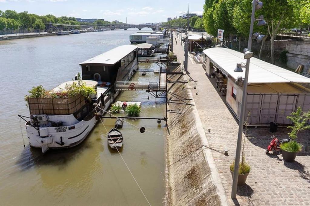 a boat is docked at a dock on a river at Modern Design One Bedroom Apartment in Paris
