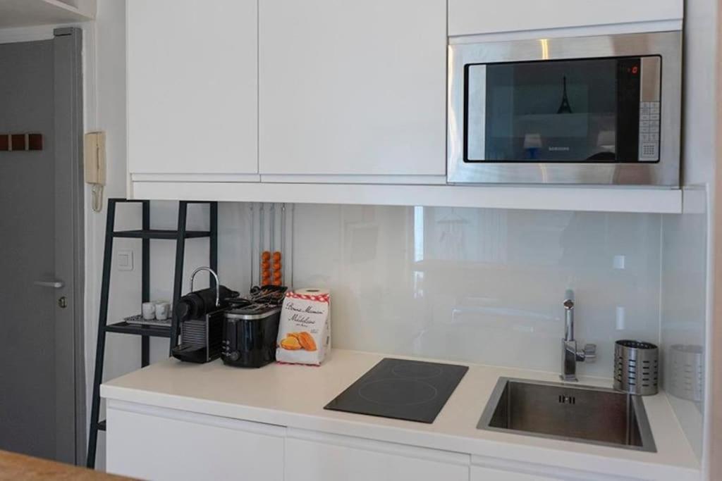 a kitchen counter with a sink and a microwave at Modern Design One Bedroom Apartment in Paris