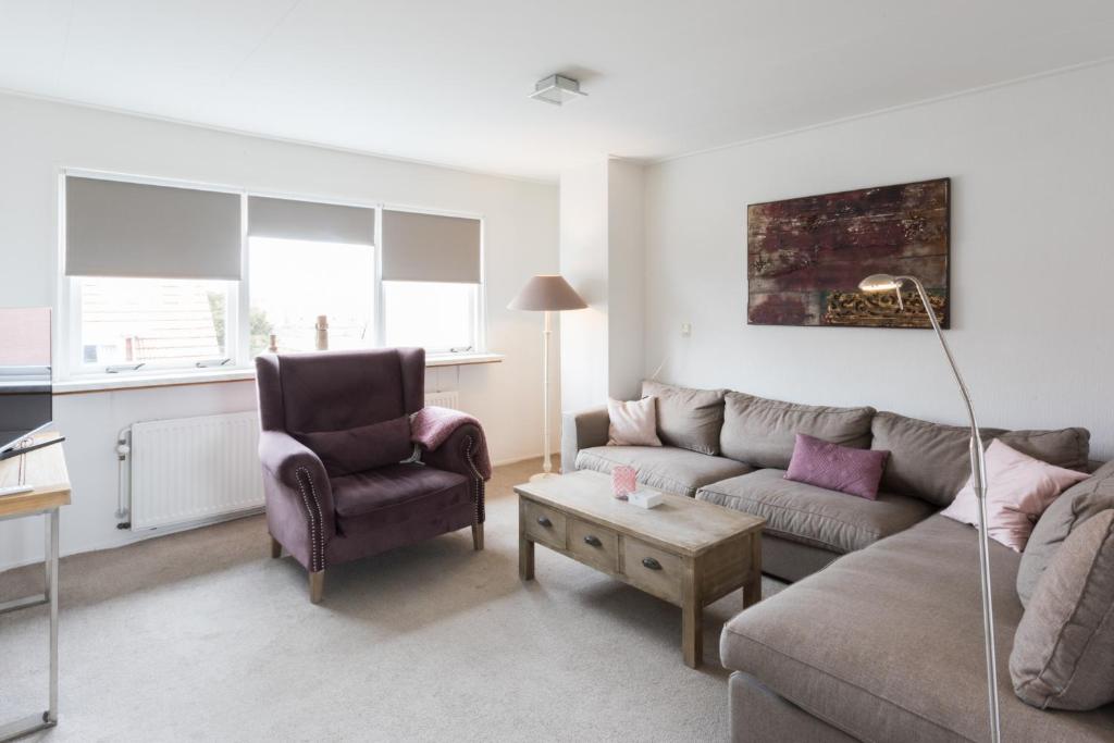 sala de estar con sofá y silla en Hello Zeeland - Appartement Weststraat 14 en Domburg