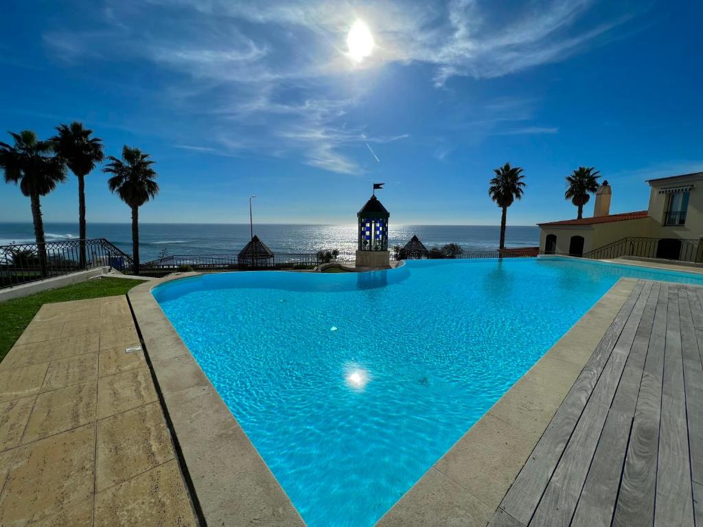 a swimming pool with the ocean in the background at Lux Parede Ocean View in Parede