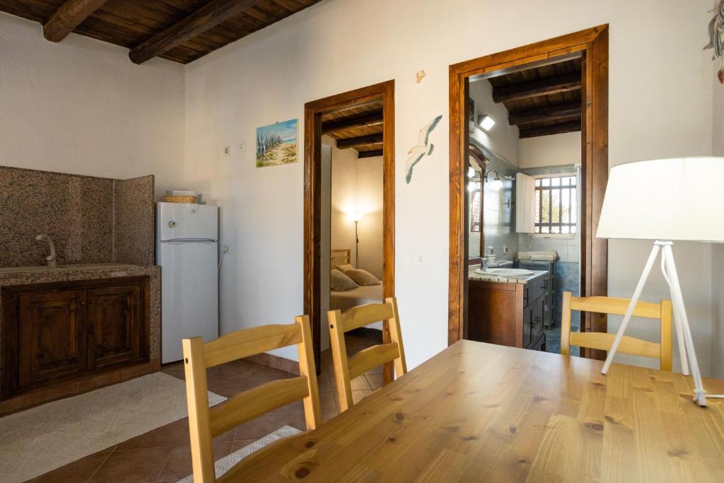 a kitchen and dining room with a table and a refrigerator at Dammusi Ziunì in Lampedusa