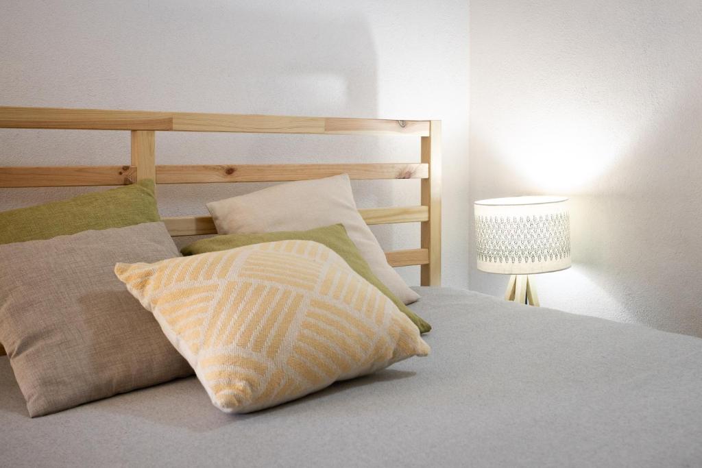 a bedroom with a bed with two pillows and a lamp at Dammusi Ziunì in Lampedusa