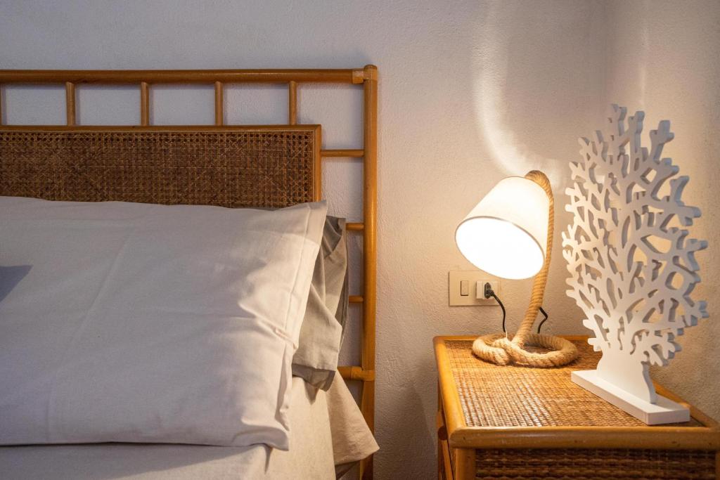 a bedroom with a bed and a lamp on a night stand at Dammusi Ziunì in Lampedusa