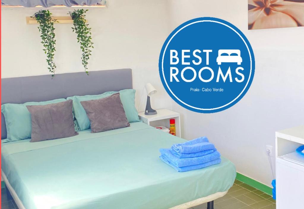 a bedroom with a bed with a sign that reads best rooms at Best Rooms - Quarto 1 Plateau in Praia