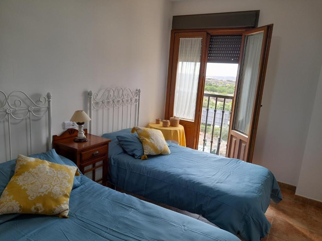 1 dormitorio con 2 camas y balcón en Finim Solis Apartamentos, en Ayamonte