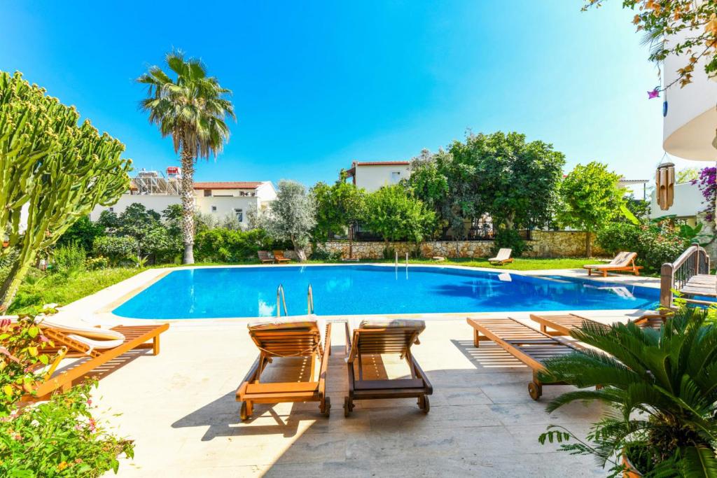 een zwembad met ligstoelen en een villa bij Duplex House with Shared Pool near Beach in Kalkan in Kalkan