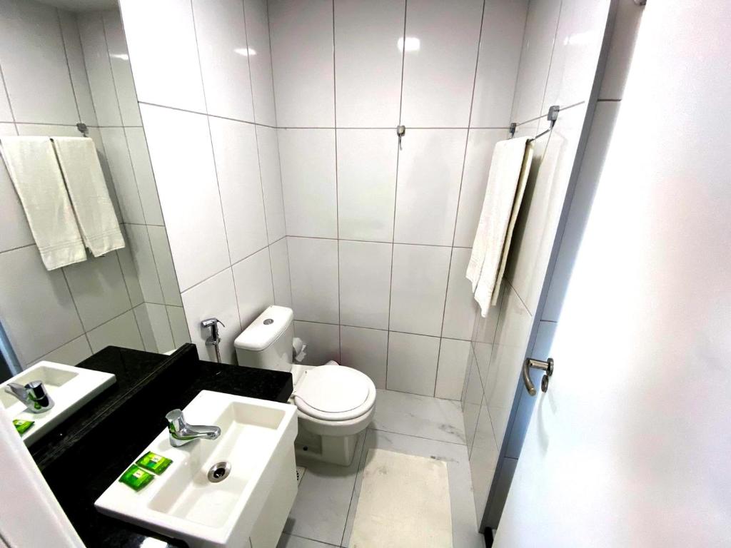 uma casa de banho branca com um WC e um lavatório em Fortaleza Sul Flats Service em Fortaleza